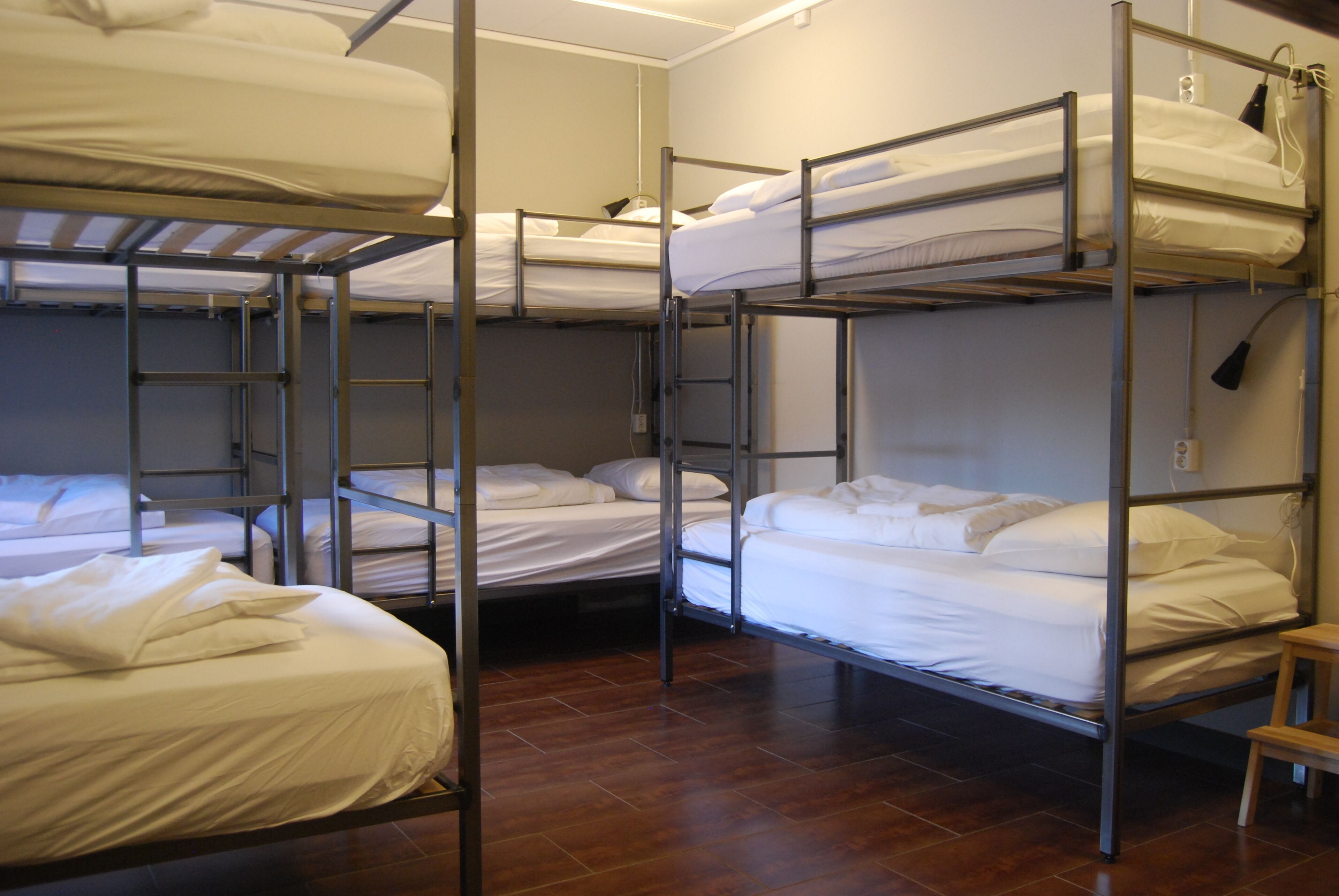 A dormitory-style room with bunk beds arranged in two rows.