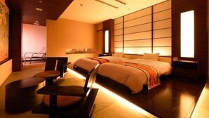 Ein modernes Hotelzimmer mit einem großen Bett, einem Schreibtisch und einem Sessel.