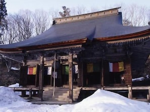 A traditional building with a sloped roof and wooden structure. - Hotel Ohsho (Tendo)