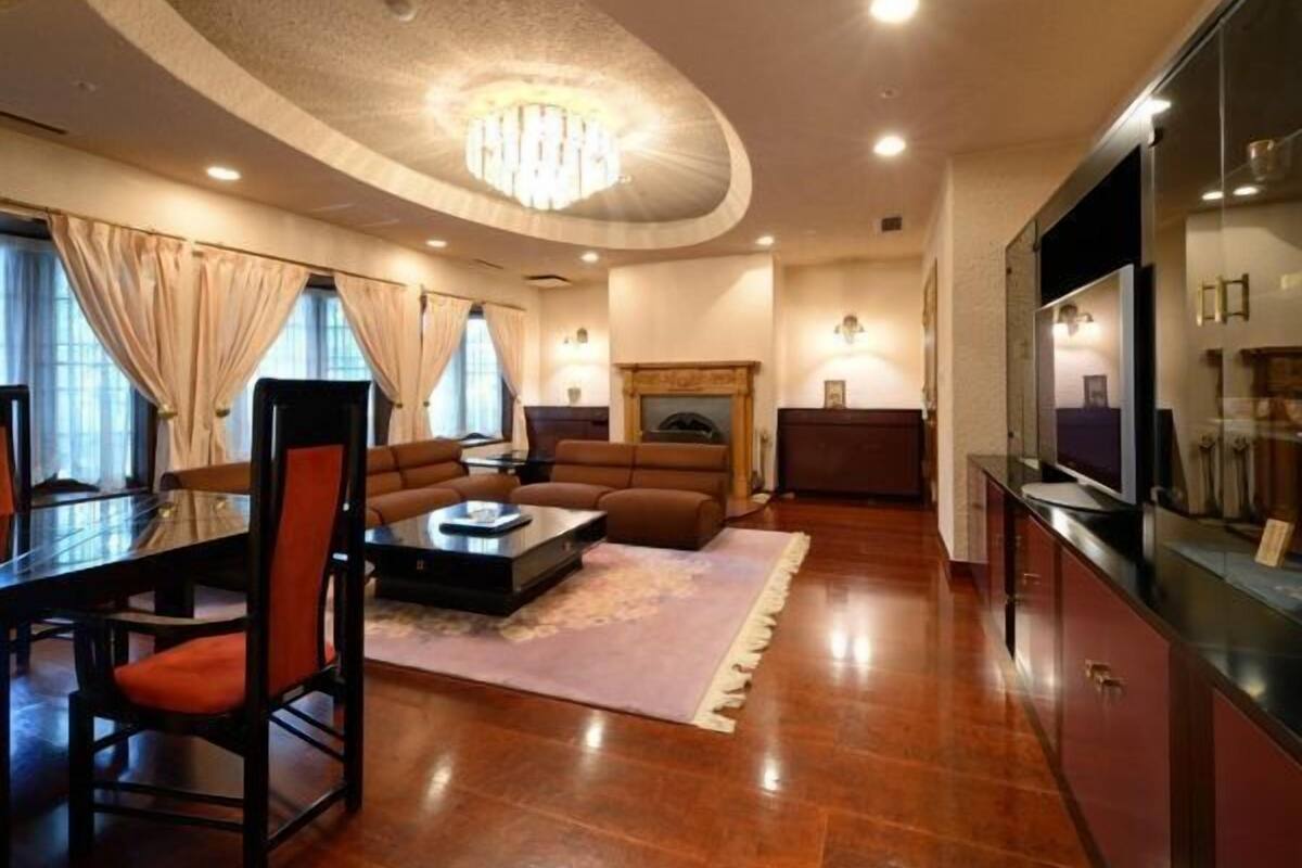 Un salon moderne avec une cheminée, un coin repas avec une table et des chaises, et un téléviseur posé sur un meuble.