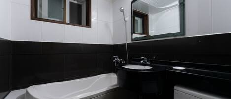 Un baño moderno con bañera, lavabo e inodoro.