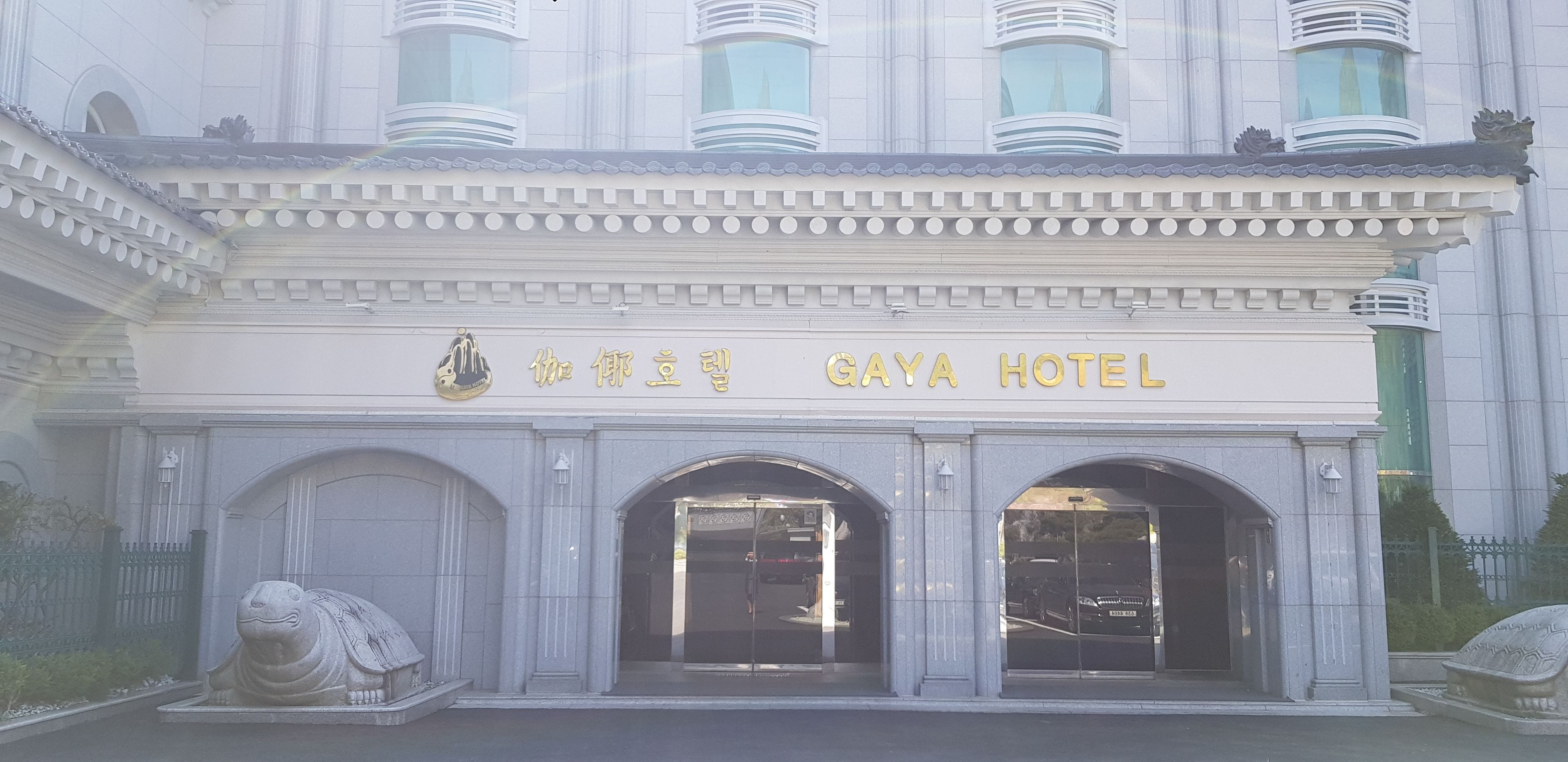 Der Eingang des GAYA HOTEL mit traditioneller Architektur, mit einem zentralen Eingang, der von zwei steinernen Löwenstatuen gesäumt wird.