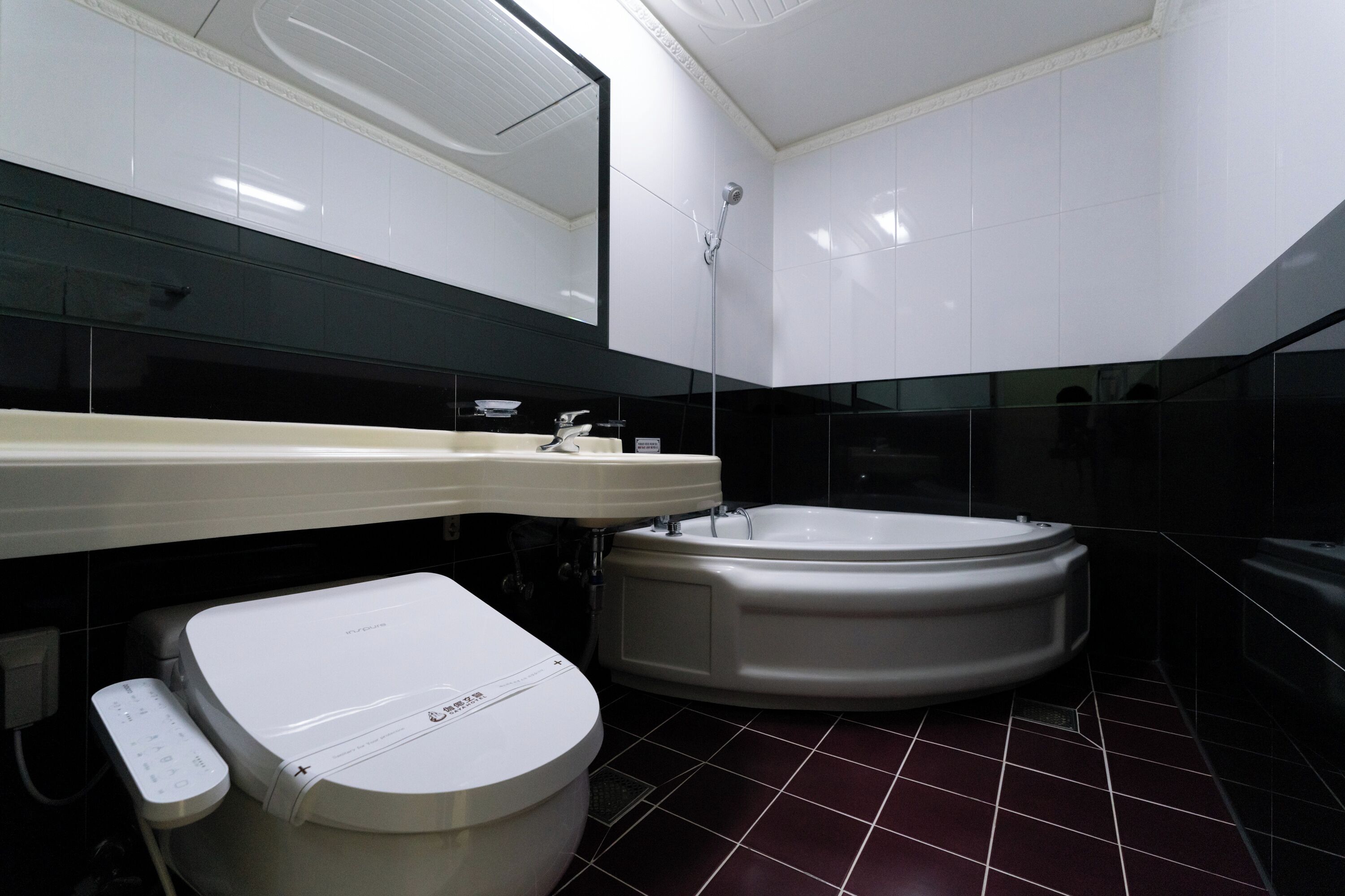 A modern bathroom with a toilet, sink, and bathtub.