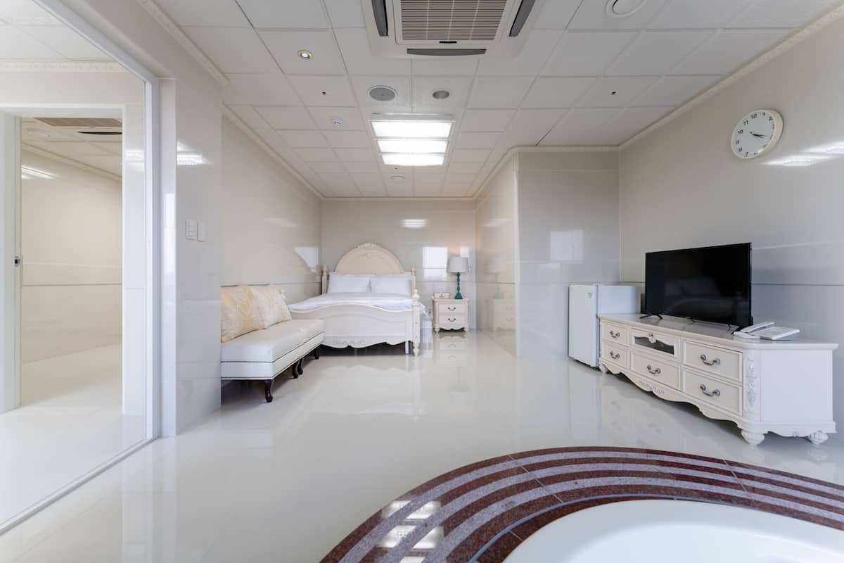 Une chambre spacieuse et moderne, dotée d’un grand lit, d’une télévision et d’une commode.