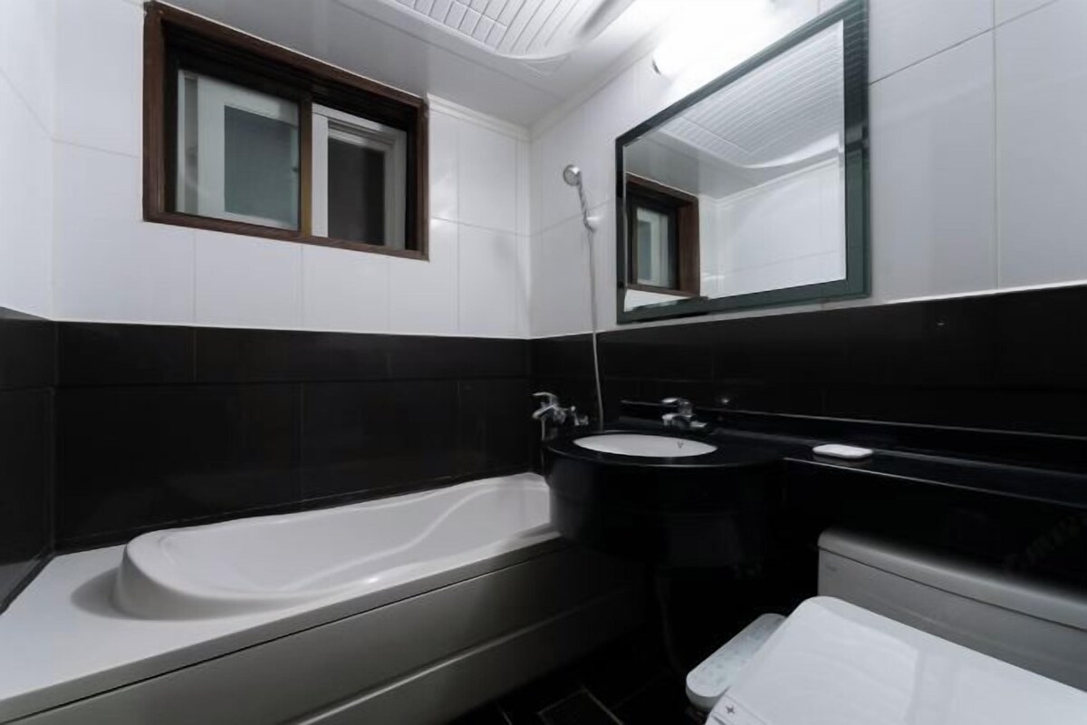 A modern bathroom with a bathtub, a sink, and a toilet.
