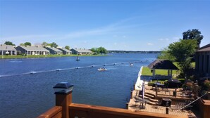 A waterfront view with boats on the water, a gazebo, and a deck with outdoor seating.