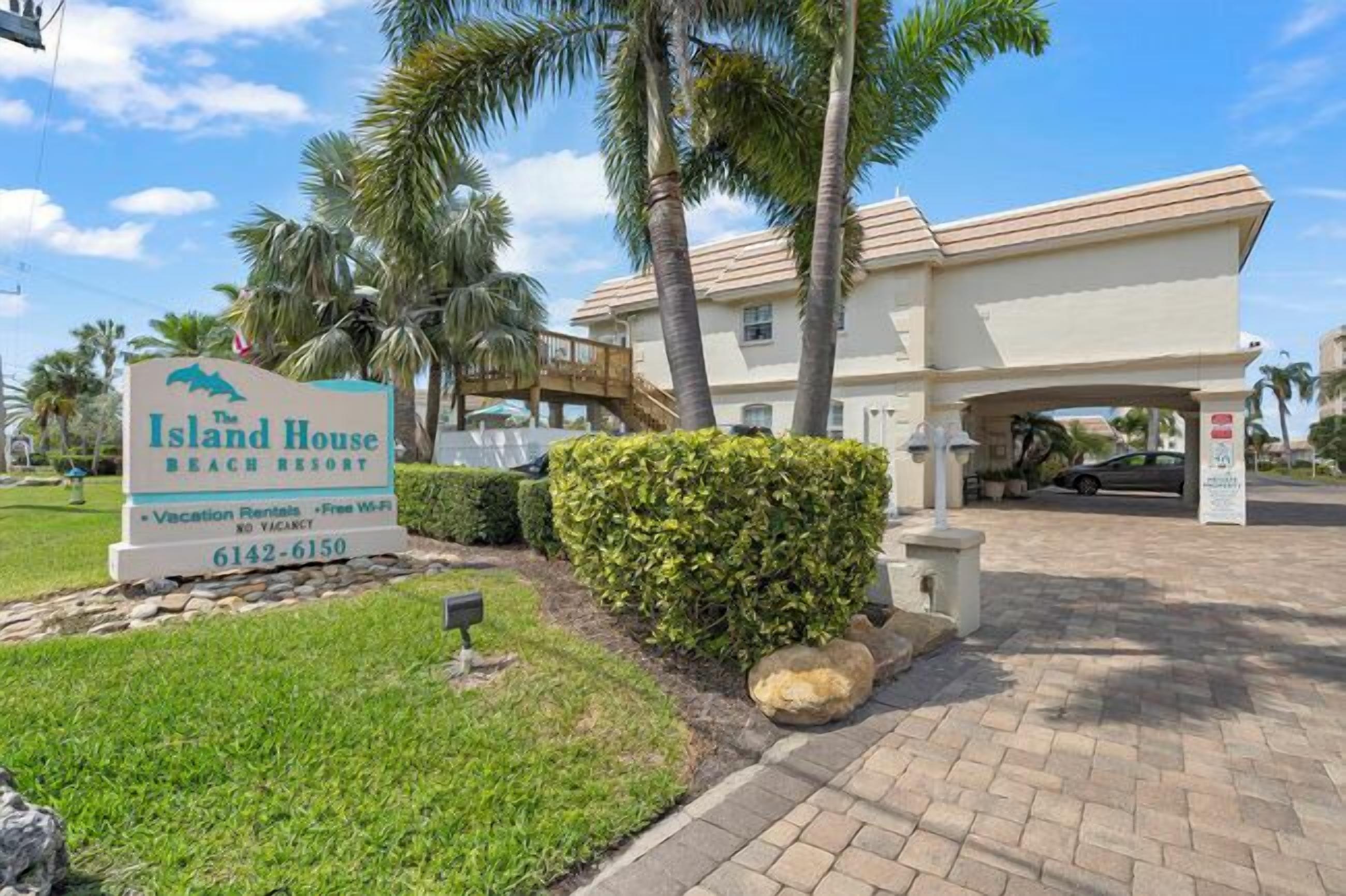 The Island House Beach Resort sign with contact number 6142-6150.
