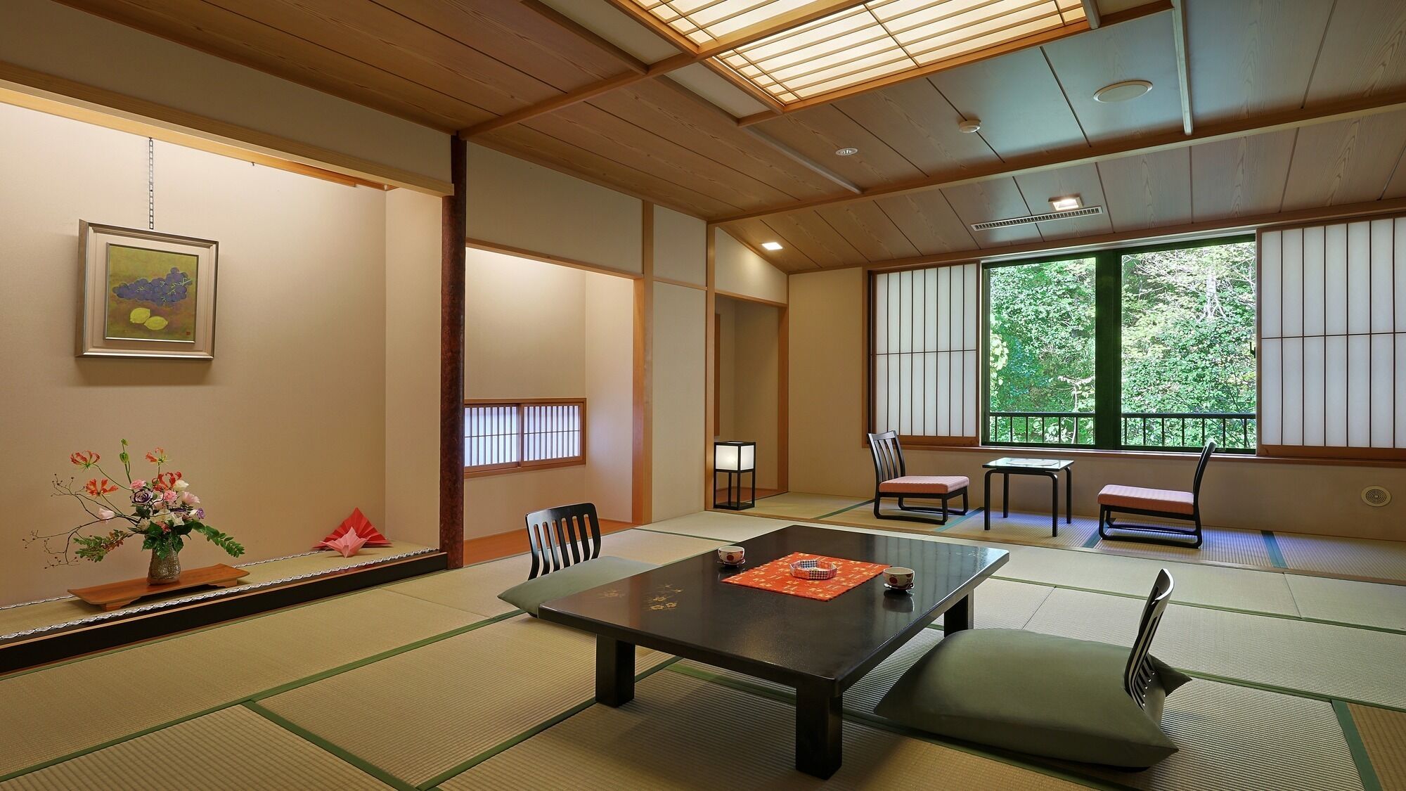 Una habitación japonesa tradicional con suelo de tatami, una mesa baja y puertas correderas.