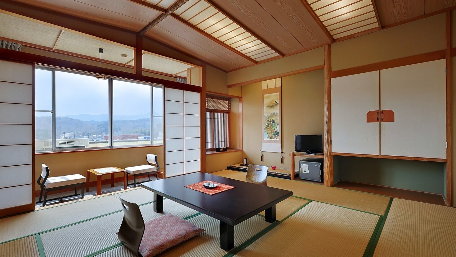 Una habitación japonesa tradicional con suelo de tatami, una mesa baja y puertas correderas.