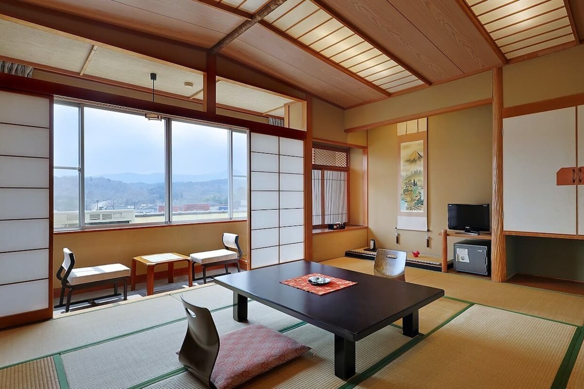 A traditional Japanese room with tatami flooring, a low table, and sliding doors.