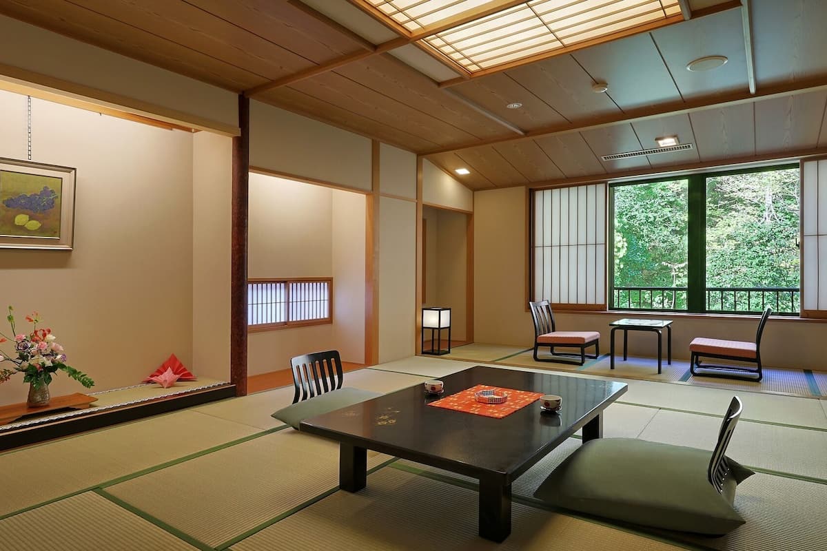 A traditional Japanese room with tatami flooring, a low table, and sliding shoji doors.