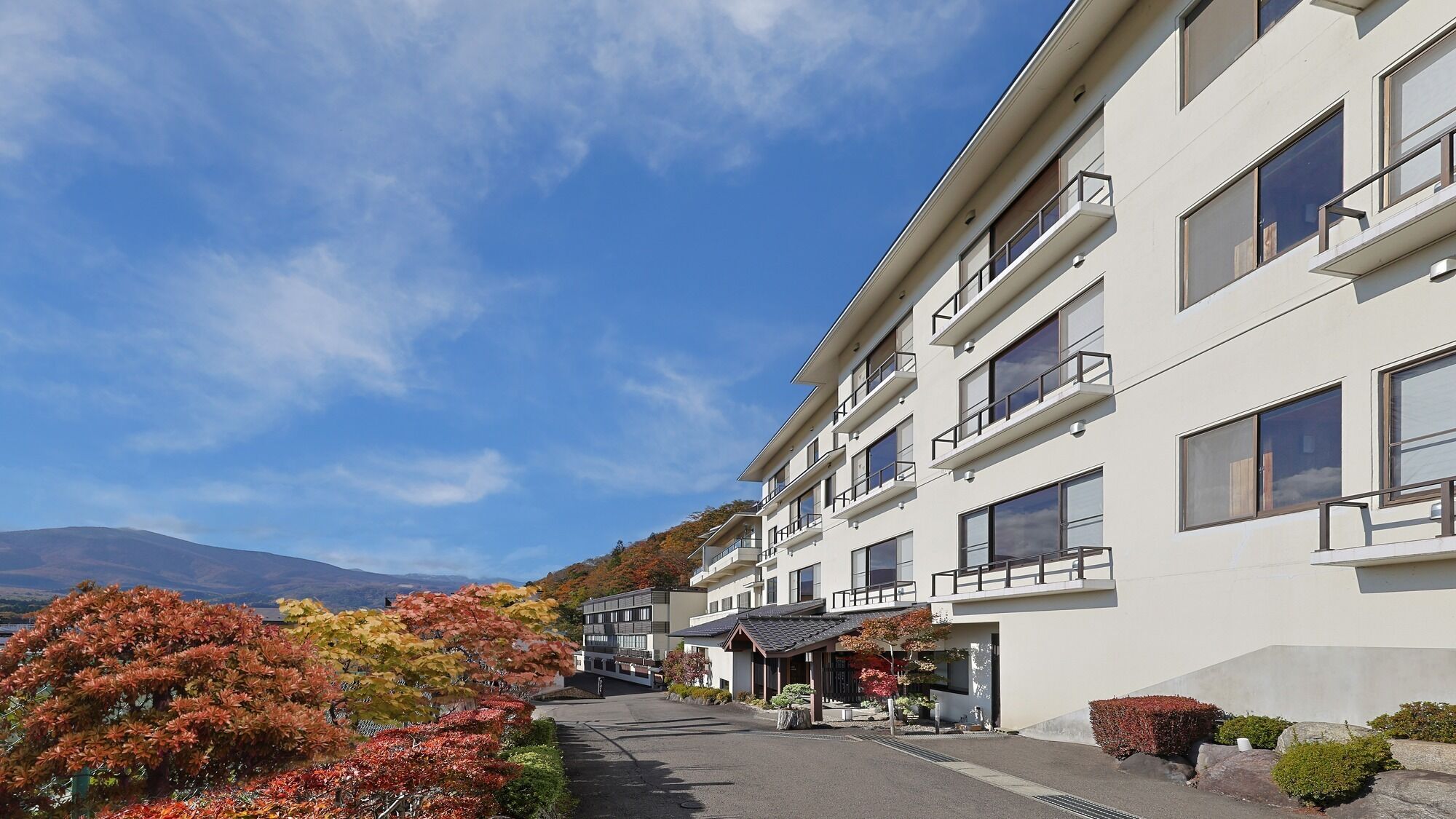 Un hotel de varios pisos con diseño moderno, que cuenta con balcones y grandes ventanales.