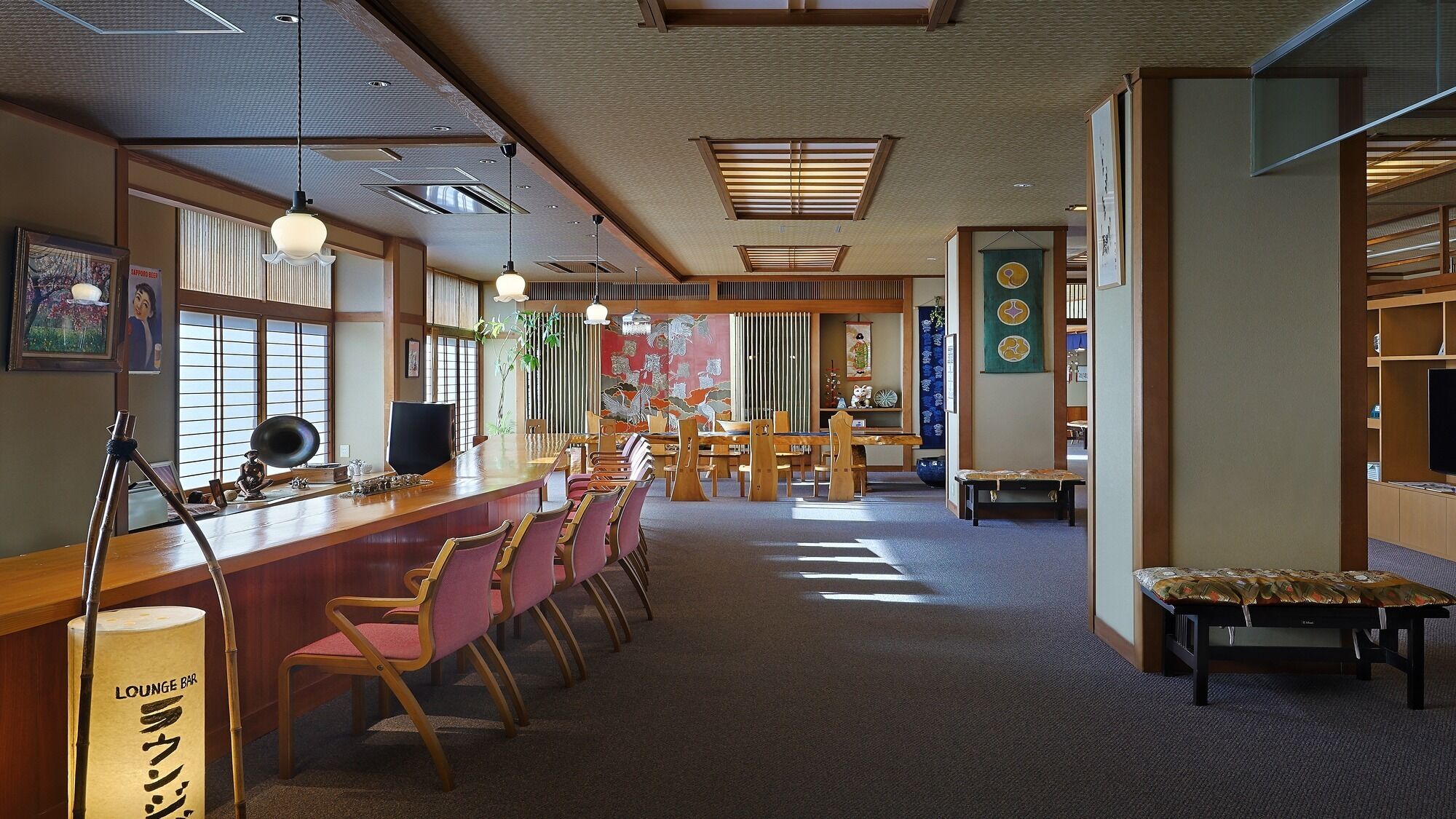 Un restaurante japonés tradicional con mobiliario de madera, una zona de bar y puertas correderas.