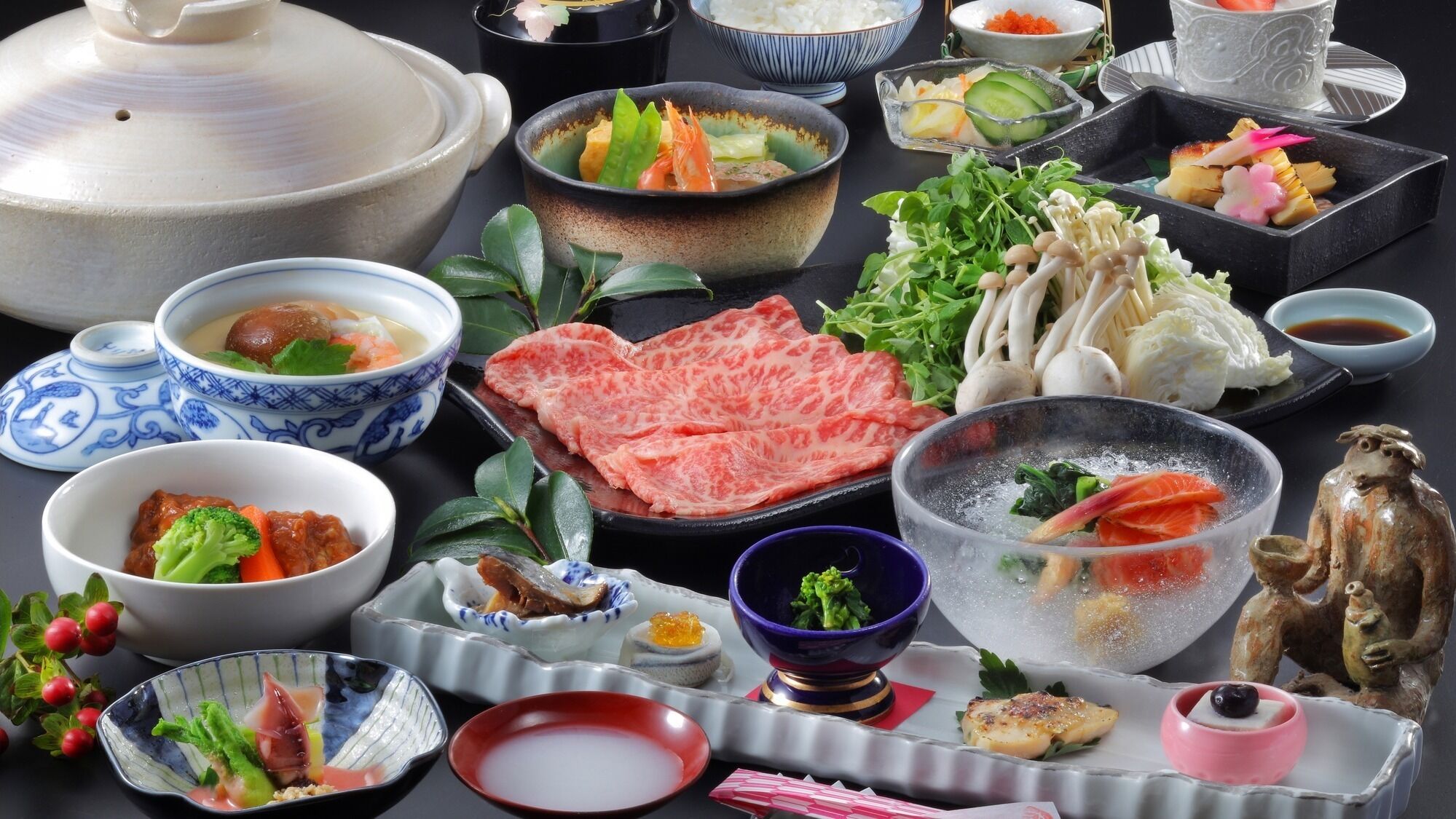 A variety of Japanese dishes including sushi, sashimi, and a hot pot.