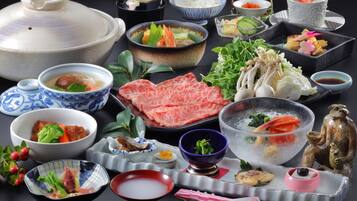 A variety of Japanese dishes including sushi, sashimi, and a hot pot.
