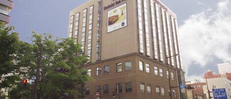 A high-rise building with a sign for Daiichi Inn Park, featuring multiple windows and a visible advertisement.