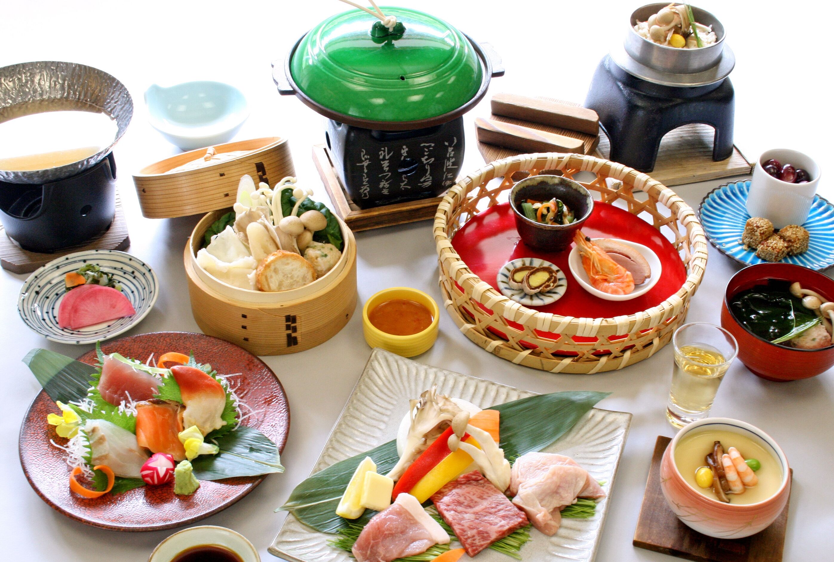 A variety of Japanese dishes arranged on a table, including sushi, sashimi, and other traditional foods.