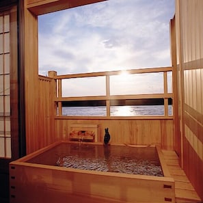 A wooden room with a large window overlooking a body of water.