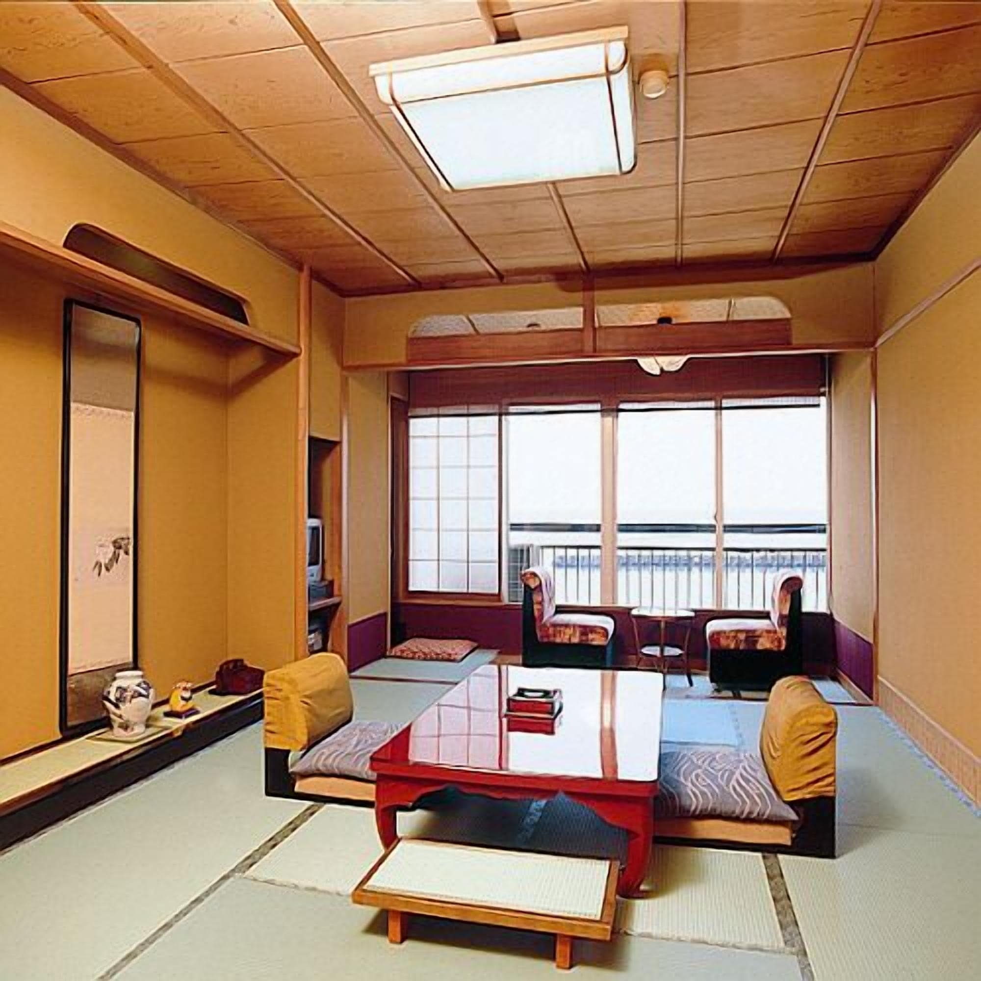 Una habitació japonesa tradicional amb tatamis, taules baixes i coixins.
