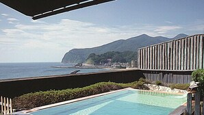 Ein Pool mit Blick auf das Meer und die Berge.