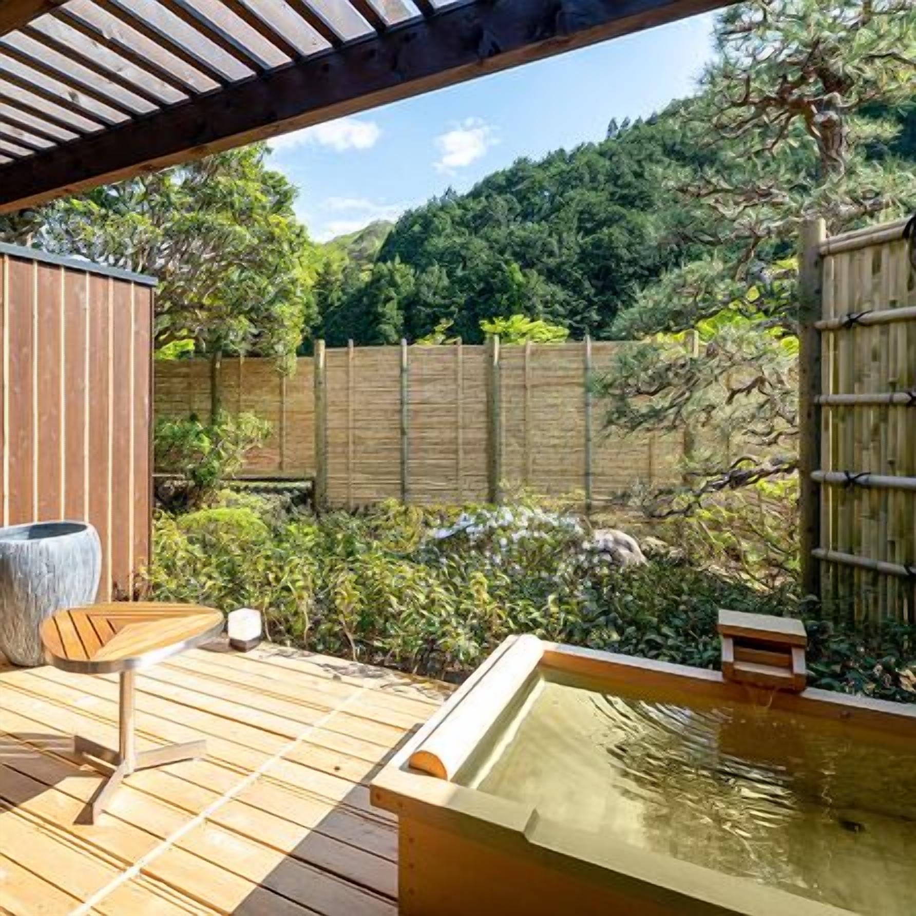 A wooden deck with a hot tub, a seating area, and a stone planter.