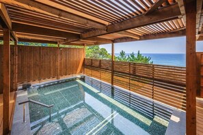 A wooden deck with a pool, wooden railings, and a view of the ocean. - Shirakabeso (Izu)