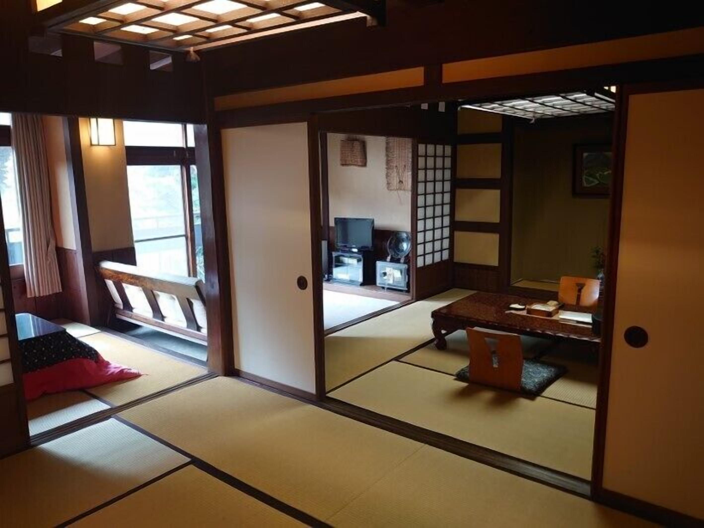 Een traditionele Japanse kamer met tatami vloerbedekking, een lage tafel en schuifdeuren.