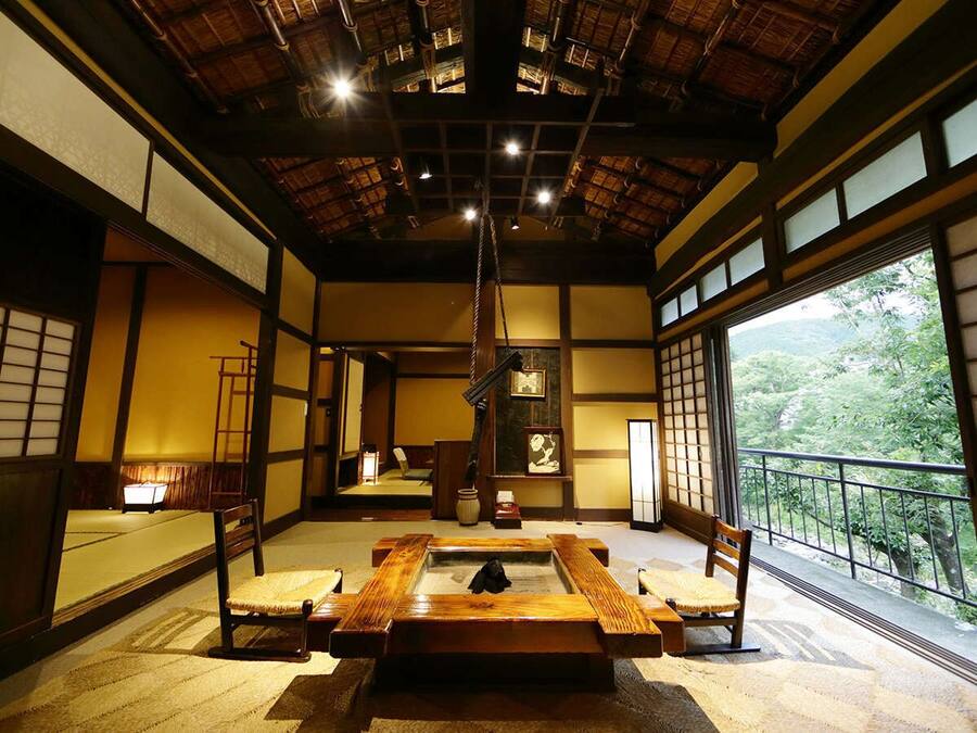 A traditional Japanese room with tatami flooring, a low table, and sliding doors.