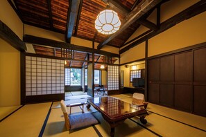 Een traditionele Japanse kamer met tatami matten, een lage houten tafel en schuifdeuren.