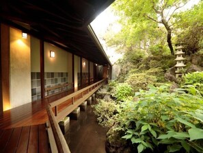 A traditional Japanese building with a wooden deck and a stone lantern. - Shirakabeso (Izu)