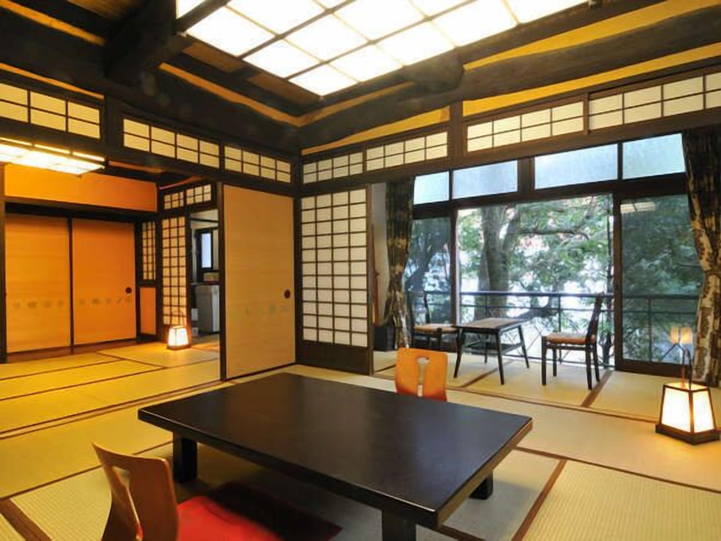 Una habitació japonesa tradicional amb terra de tatami, una taula baixa i portes corredisses.