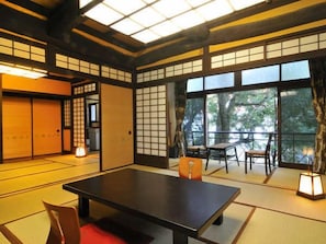 A traditional Japanese room with tatami flooring, a low table, and sliding doors. - Shirakabeso (Izu)
