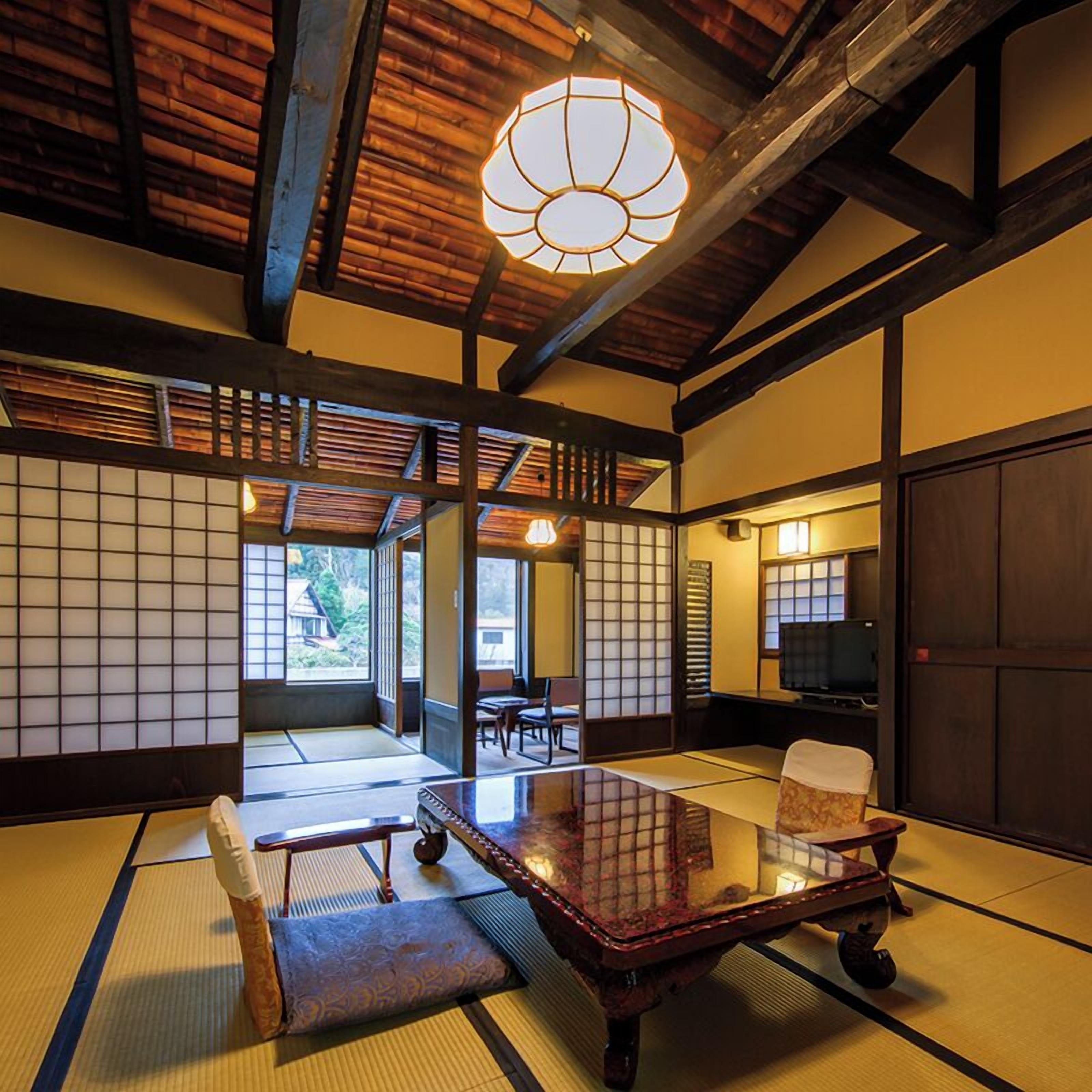 A traditional Japanese room with tatami flooring, a low table, and sliding doors.