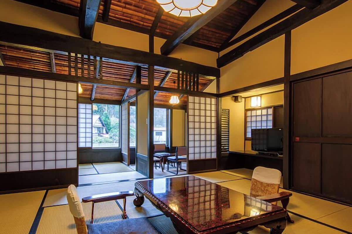 Ein traditioneller japanischer Raum mit Tatami-Böden, einem niedrigen Tisch und Schiebetüren.