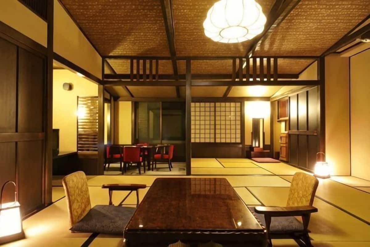 Ein traditioneller japanischer Raum mit Tatami-Bodenbelag, einem niedrigen Tisch und Stühlen.