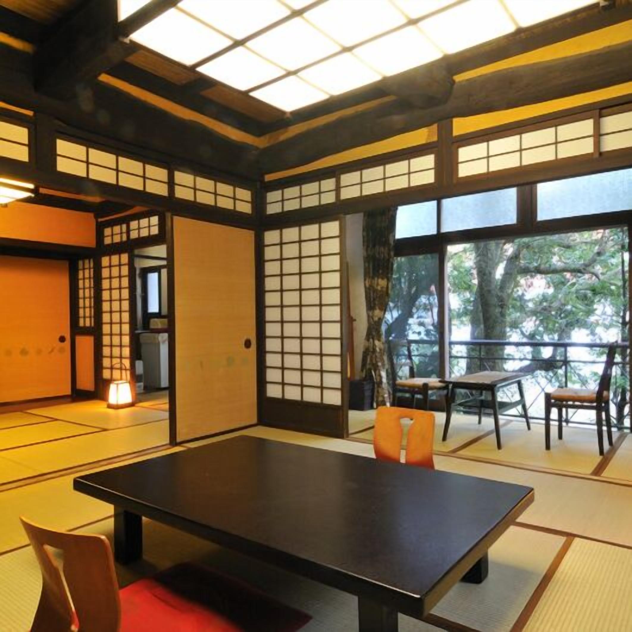 Een traditionele Japanse kamer met tatami vloerbedekking, een lage tafel en schuifdeuren.