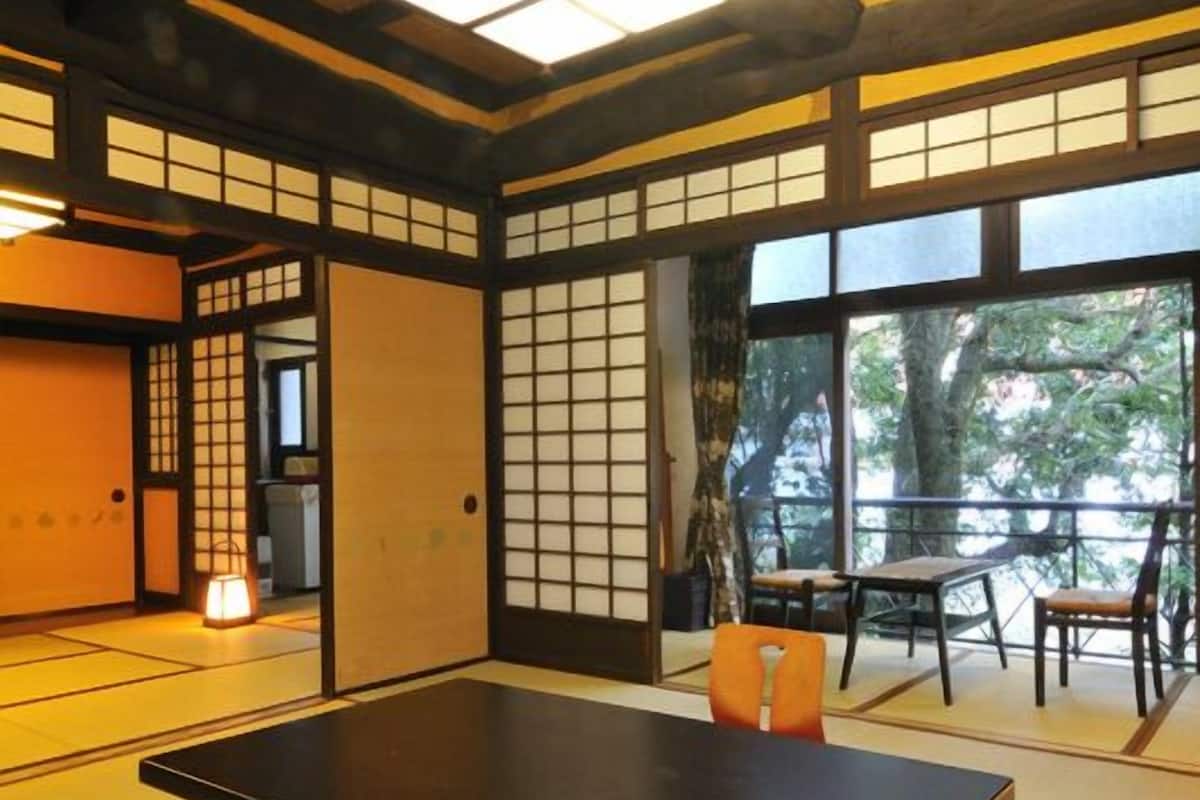Ein traditioneller japanischer Raum mit Tatami-Böden, einem niedrigen Tisch und Schiebetüren.