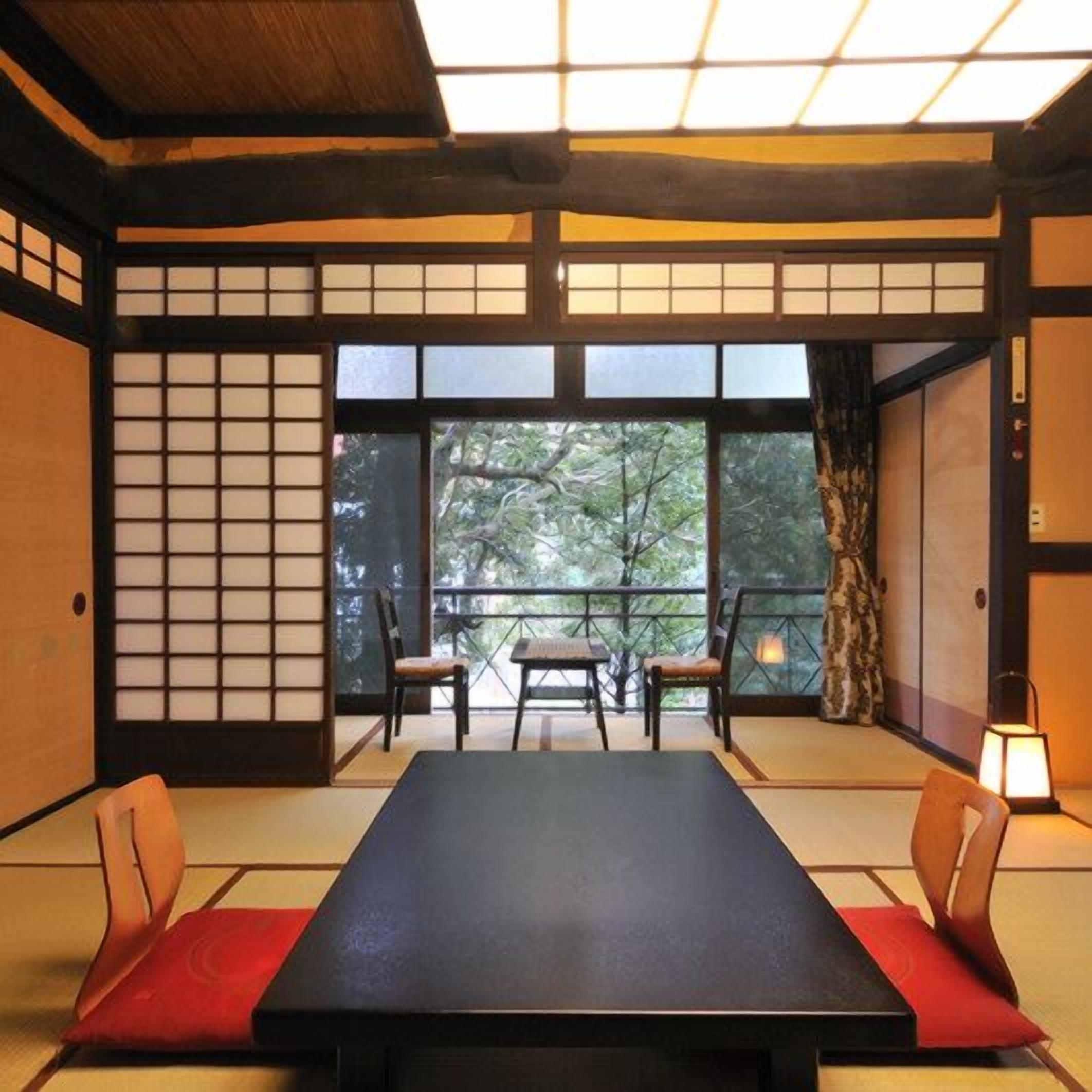A traditional Japanese room with tatami flooring, a low table, and sliding doors.