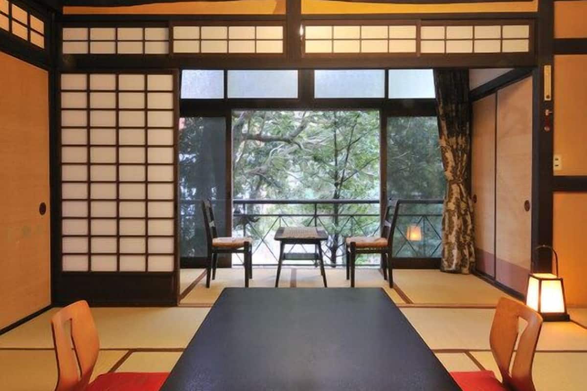 Ein traditioneller japanischer Raum mit Tatami-Böden, einem niedrigen Tisch und gleitenden Türen.
