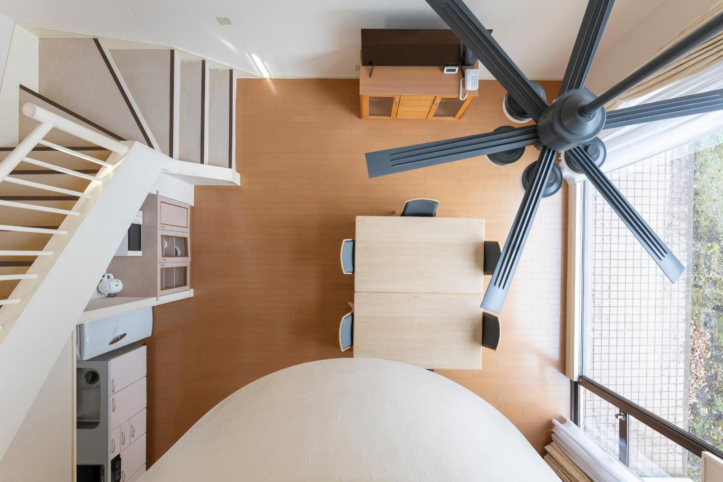 A modern interior with a dining area, kitchen, and staircase.