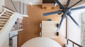 A modern interior with a dining area, kitchen, and staircase.