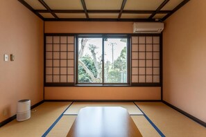 A traditional Japanese room with tatami flooring, a shoji screen, and a futon bed. - Le Nessa Jogasaki (Ito)