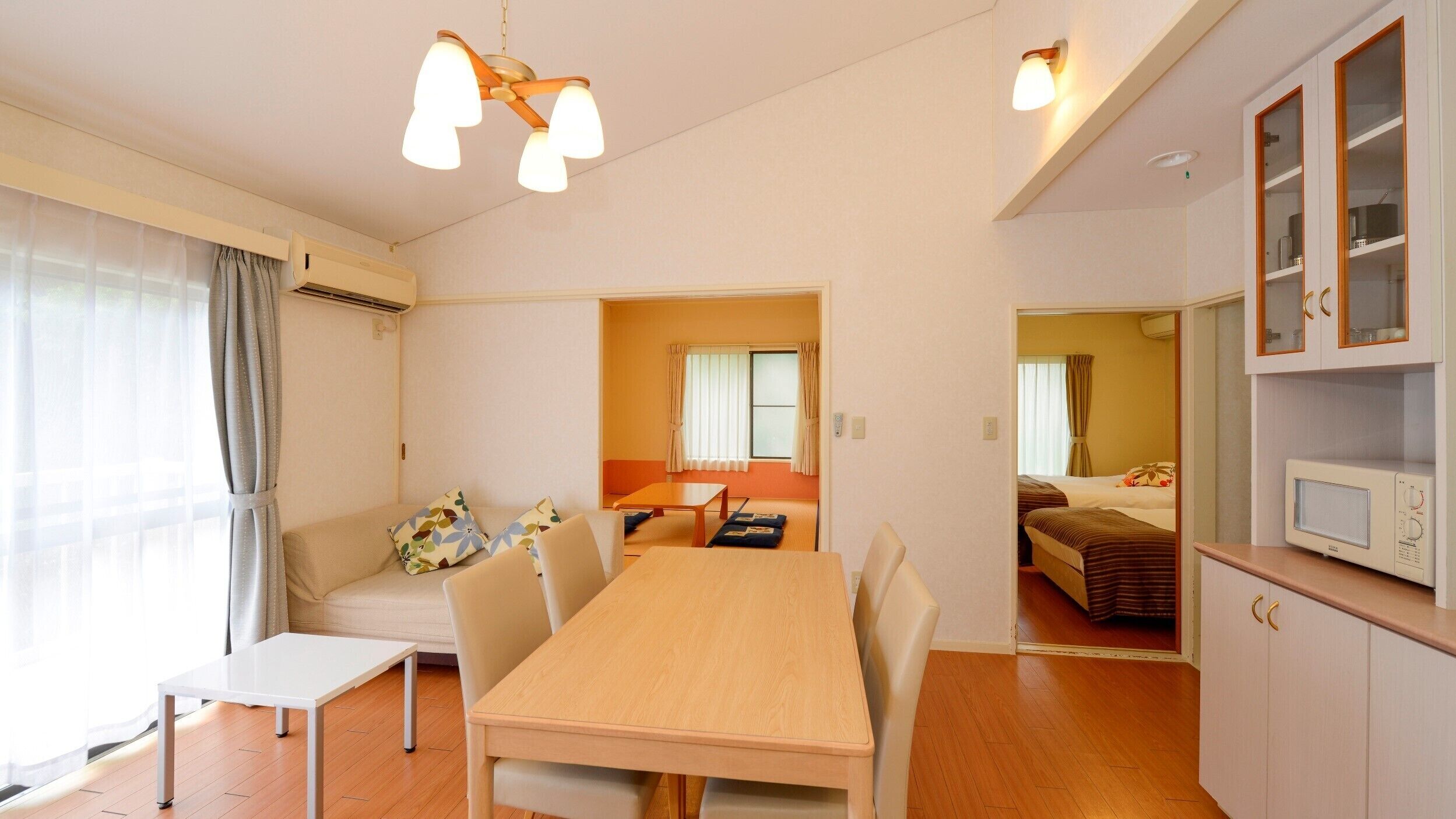 Quarto de hotel compacto com área de jantar, cozinha compacta e uma cama.