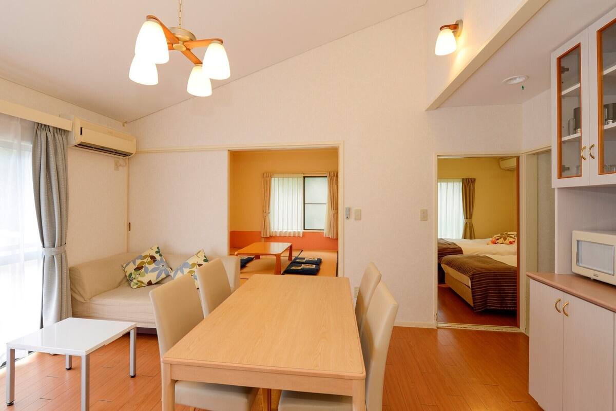 Ein kleines Hotelzimmer mit Essbereich, einer Küchenzeile und einem Bett.