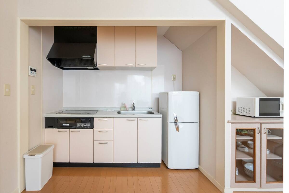 Eine kleine Küche mit Mikrowelle, Kühlschrank und Geschirrspüler.