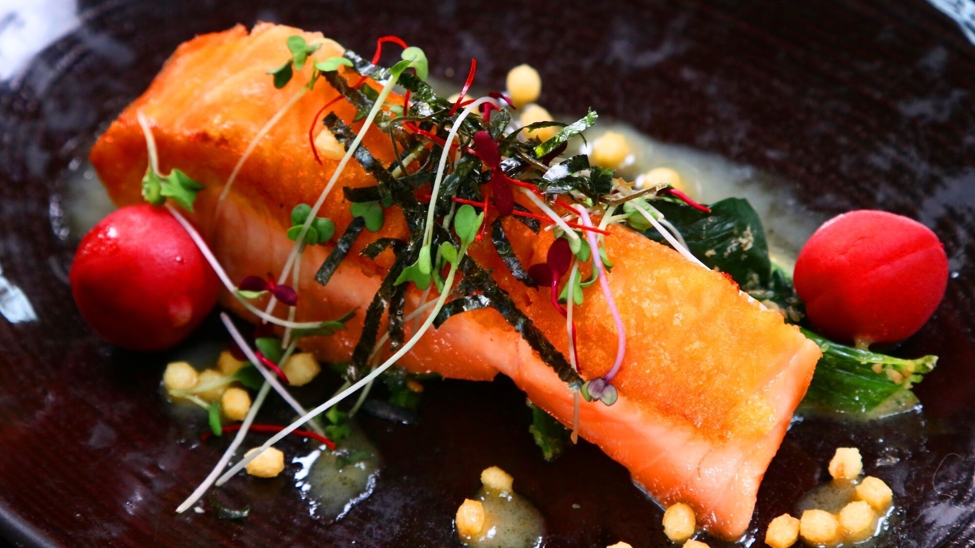 Ein Gericht mit Lachs, Salat und Radieschen.