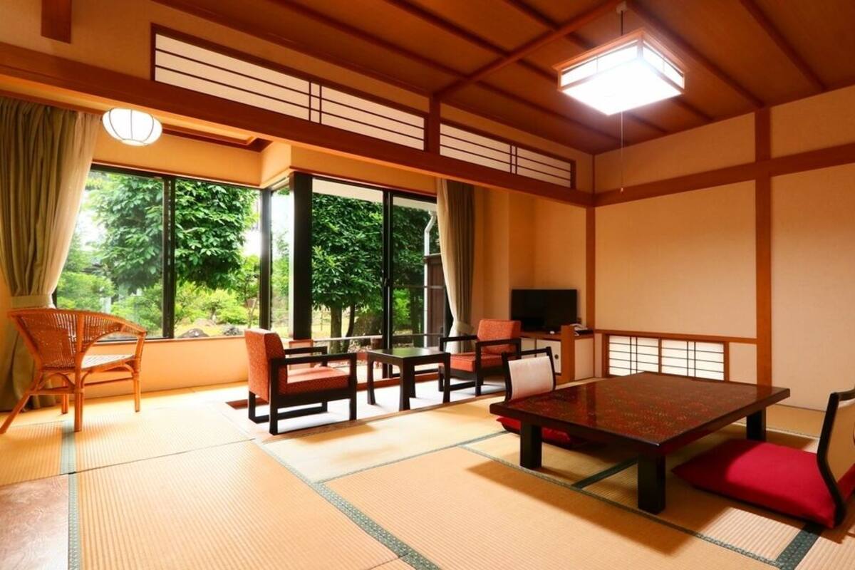 A traditional Japanese room with tatami flooring, a low table, and sliding doors.