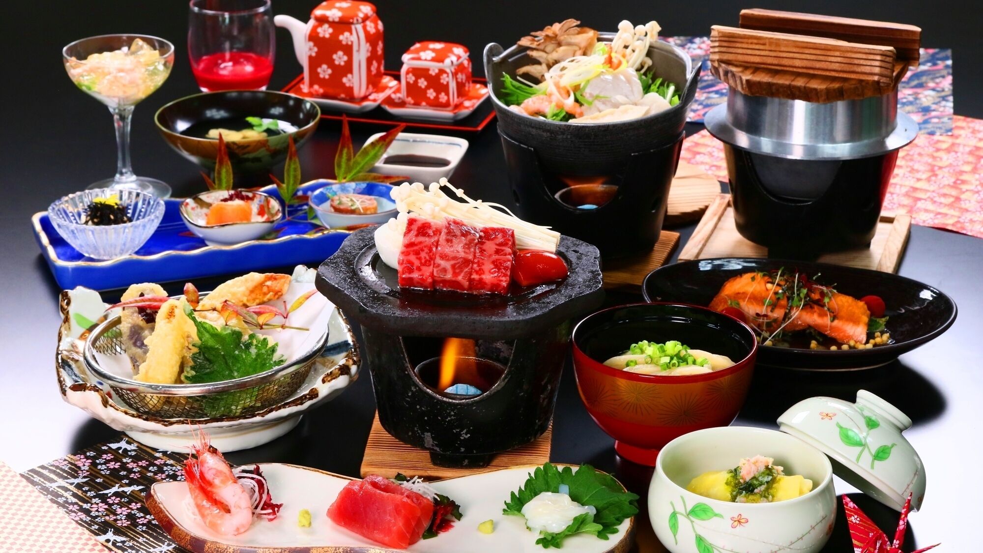 A variety of dishes and a hot pot setup on a table.