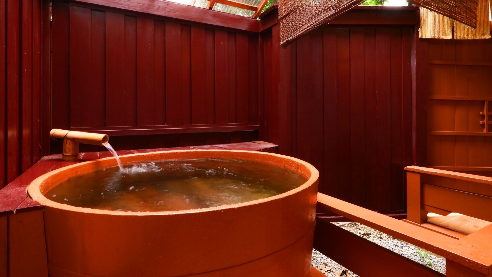 A hot tub with a wooden bench and a wooden wall.