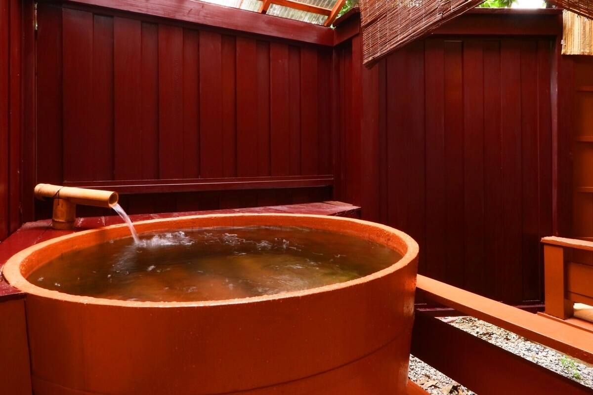 A hot tub with a wooden bench and a wooden wall.